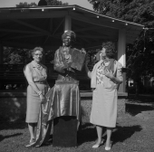 Two women standing by a statue