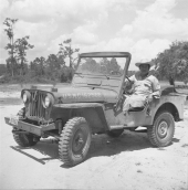 Oklahoma Seminole Indian Webster Talmsey Wise sitting in a Jeep