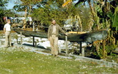 Men standing by old Seminole Indian dugout canoe - Brighton Reservation, Florida