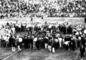 Crowd surrounding activitiy on the field at a University of Miami football game.