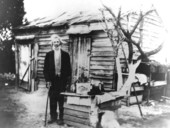 Tom Moreno standing in front of a shack - Escambia County, Florida