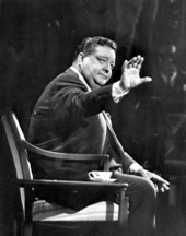 Jackie Gleason sitting on the set