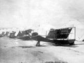 Curtiss flying boats on the beach beside tent hangars.