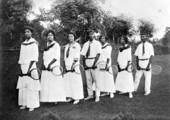 Students and instructors with tennis equipment.
