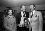 Art Linkletter holding a record by Joe Williams while standing with Friedman couple - Pinecrest, Florida.