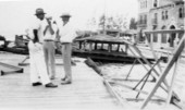 Unidentified men standing among the wreckage left by the 1928 hurricane