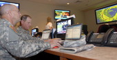 Sgts. 1st Class Jeffery Seaman (left) and Leonard Tomlinson (right) reviewing the latest Tropical Storm update.