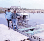 Seminole Indian men with an airboat in the Everglades.