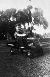 LeRoy Collins, Jr., driving a toy car.