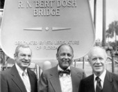 Farris Bryant and others in front of bridge memorial sign.