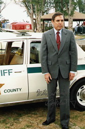 Florida Governor Bob Martinez standing next to a Sheriff's car.