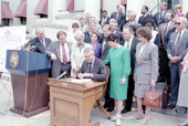 Florida Governor Chiles signing a bill on the steps of the old Capitol building.
