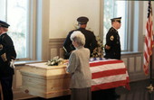 Rhea Chiles placing white flowers on Governor Chiles' casket