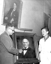 Tom Adams standing with Portrait of William Marvin