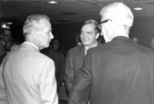 United States Senator Lawton Chiles, center facing camera, speaking with two gentlemen.