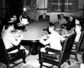 Unidentified men sitting around a large table