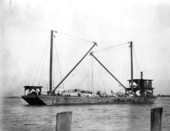 Derrick barge in Mayport, Florida loaded with rock brought from North and South Carolina by train to be used as fill.
