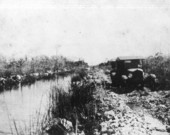 Two cars running on the road by canal - Tamiami Trail, Florida