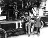 Sig Haugdahl (center) sitting on Frontenac automobile beside Mabel Cody.