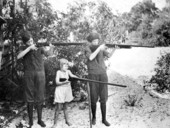 Two women and girl posing with guns on Saint George Island, Florida.