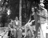 Johnie Sheffield and Johnny Weissmuller watch as Jean Knapp gets her make-up during filming of "Tarzan's Secret Treasure".