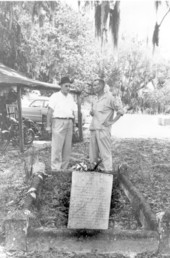 Two men standing before the grave of Arabella "Polly" Taylor - Enterprise, Florida