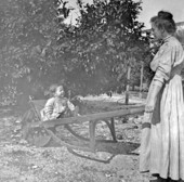 Mrs. Rynearson with her son Jim in wheelbarrow - Saint Andrews, Florida