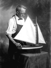 Portrait of photographer Charles Thomas Cottrell with boat model.