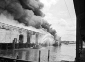 View of fire at the docks being fought by firefighters in a fireboat - Jacksonville, Florida.