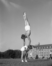 Gymnast Howard "Beans" Stephens doing a handstand while balancing on Nancy Lamb's back at the FSU campus.