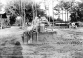 Unidentified worker measures a Caterpillar Tractor Scraper