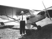 Man standing by an airplane at Penney Farms.