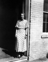 Woman standing in a building doorway.
