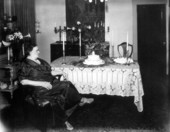 Seated woman sitting beside a tables.