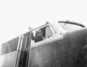 Railroad engineer waving from engine.