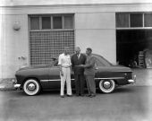Men standing with a car.