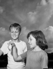 Patsey Moore showing her brother the fish she caught during the Fishathon at Lake Ella in Tallahassee, Florida.
