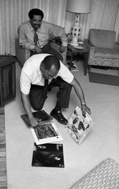 Cannonball Adderley at home with his father J.C. looking at phonograph records in Tallahassee.