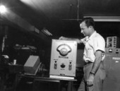 J. L. Moody, engineer, examines "indexometer", new electronic device which measures thickness of orange juice concentrate.
