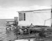 Unidentified man works on a dock behind a building - Card Sound, Florida.