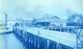 Barrels being moved between steamboat and building at dock in Carrabelle, Florida.