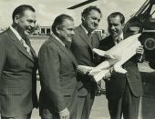 Nixon holds a model of the Space Shuttle and its transport plane while standing with Governor Claude Kirk and Congressman Bill Cramer at the airport in St. Petersburg.
