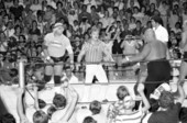 Pro wrestler Dusty Rhodes in ring with opponent during wrestling event held at the Key West High School gymnasium..