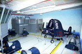 F-4U "Corsair" fighter on display next to simulators inside the "Fantasy of Flight" air museum.