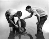 Biologist Jim Barkuloo and unidentified GFC employee releasing fish into the water.