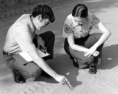 Unidentified game and fish officers looking at vehicle tracks