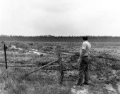 Game and fish officer looks over a field .