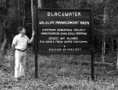 Wildlife biologist Charlie Turner near Blackwater Wildlife management area's sign.