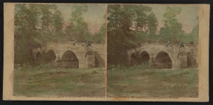 Hand-colored print showing an eastern view of the Burnside Bridge over Antietam Creek in Maryland with soldiers sitting on the top of the stone bridge.